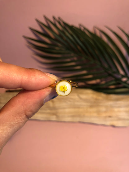 anneau serti de résine renferme une fleur jaune d’alysse